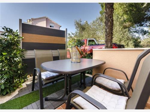 een tafel en stoelen op een patio met een tafel bij Apartmani Adele in Srima