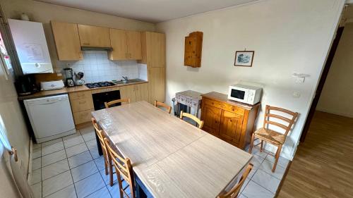 Il comprend une cuisine avec une table et des chaises en bois. dans l'établissement Le Therminus 42 - Le Mont Dore 8pers, à Mont-Dore