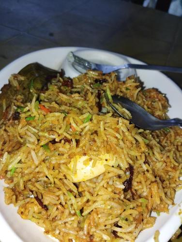 a white plate of rice with a fork on it at Jayalaxmi Hotel and lodge in Birātnagar
