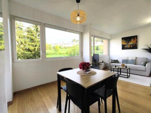 un salon avec une table, des chaises et un canapé dans l'établissement Cocon proche Genève, à Vétraz-Monthoux