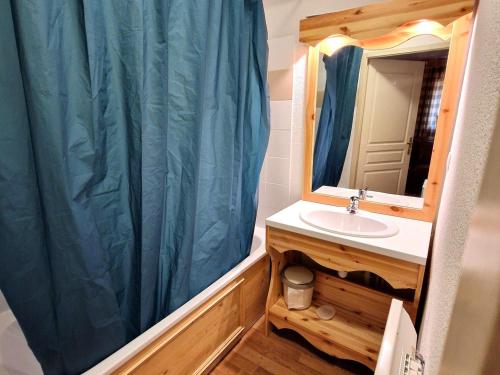 La salle de bains est pourvue d'un lavabo et d'un rideau de douche bleu. dans l'établissement Spacieux appartement 4 pièces pour 8 pers, au cœur de la station, proche télécabine et commerces - FR-1-265-64, à Valfréjus