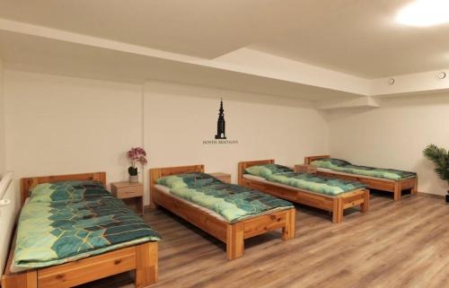 three beds in a room with wooden floors at Hostel Old Town in Bratislava