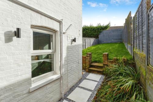 a house with a window on the side of it at Luxurious 10-Person Modern House with Garden in Central Tonbridge in Kent