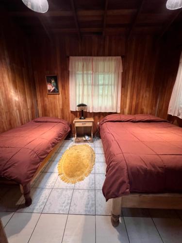 a bedroom with two beds and a rug at Los Quetzales Ecolodge & Spa in Cerro Punta
