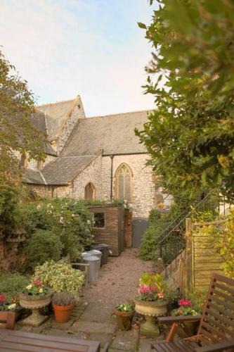 an old brick house with potted plants in front of it at St Margaret's Steps Luxury apartment sleeps 8 in Topsham
