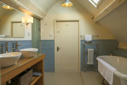 a bathroom with two sinks and a bath tub at St Margaret's Steps Luxury apartment sleeps 8 in Topsham