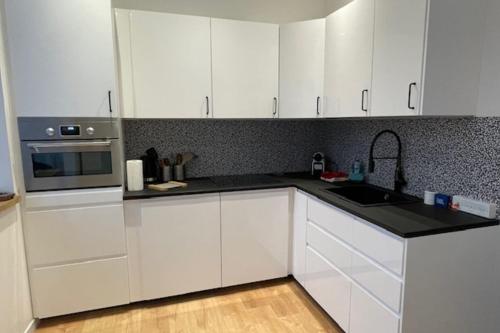 une cuisine blanche avec des armoires blanches et un évier dans l'établissement Duplex 10 minutes from the beach in Trouville, à Trouville-sur-Mer