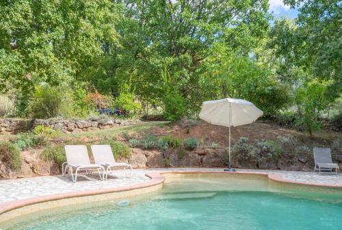 - deux chaises et un parasol dans la piscine dans l'établissement 83soleil, à Villecroze