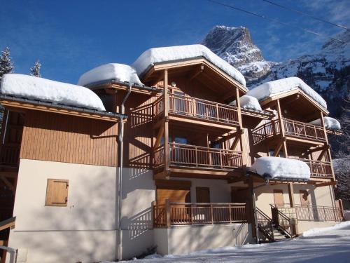 un bâtiment avec des balcons enneigés et une montagne dans l'établissement Studio cosy pour 2 - balcon, proche centre et téléphérique, animaux admis - FR-1-464-135, à Pralognan-la-Vanoise