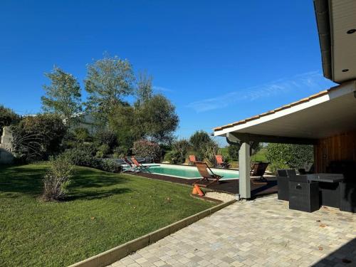 a backyard with a swimming pool and a house at Maison Bordeaux Saint Émilion in Beychac-et-Caillau