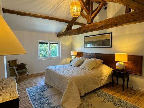 a bedroom with a bed and two lamps and a couch at Maison Bordeaux Saint Émilion in Beychac-et-Caillau