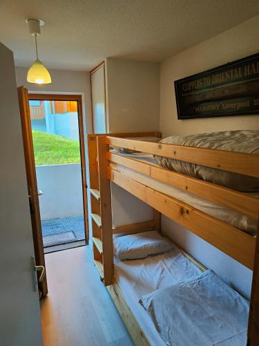 une chambre avec deux lits superposés et une fenêtre dans l'établissement Ambiance chalet et belle terrasse, à Thollon-les-Mémises