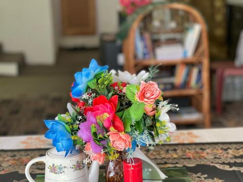 a vase filled with colorful flowers on a table at Everest Guest House in Gulmarg