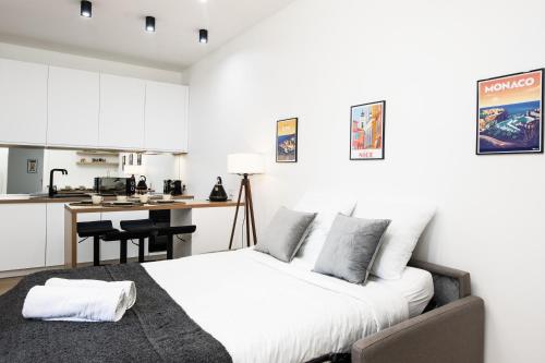 Il comprend une chambre avec un lit et une cuisine avec un bureau. dans l'établissement Monaco border - Joli appartement rénové - CK, à Beausoleil