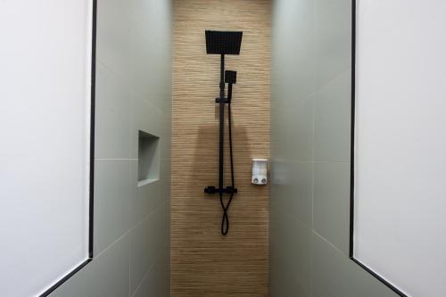 une douche dans une salle de bain avec une porte vitrée dans l'établissement Monaco border - Joli appartement rénové - CK, à Beausoleil