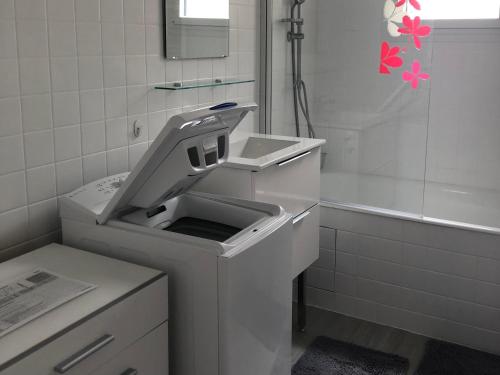 La salle de bains blanche est pourvue d'un lavabo et d'une baignoire. dans l'établissement Appartement avec balcon, proche CHU, château, Tramway, à Angers