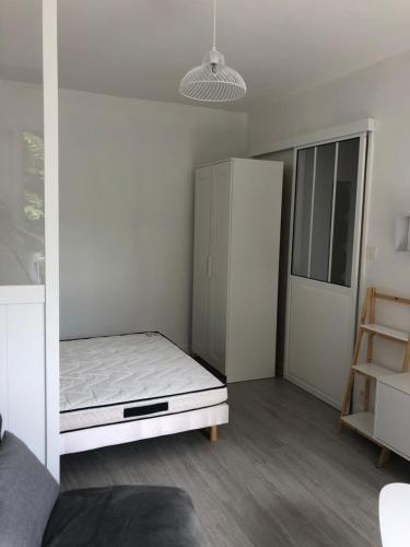 Cette petite chambre comprend un lit et un réfrigérateur. dans l'établissement Appartement avec balcon, proche CHU, château, Tramway, à Angers