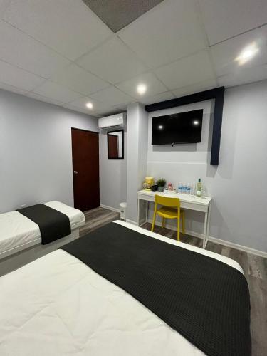 a bedroom with a bed and a desk with a tv at Hotel Libertad in Lares