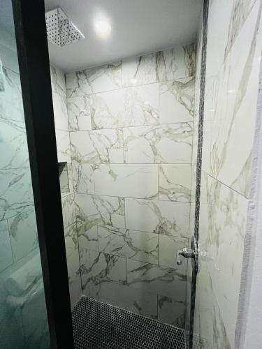 a bathroom with a shower with white marble walls at Hotel Libertad in Lares