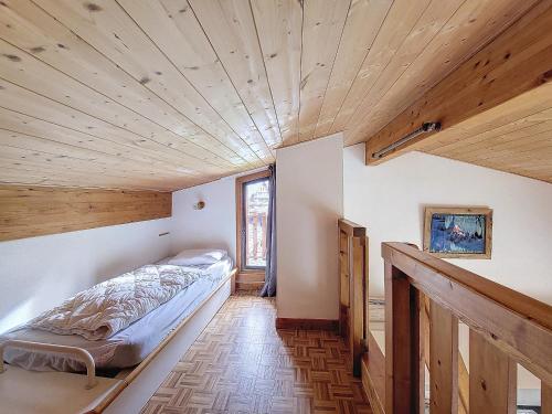 une chambre avec un lit dans une pièce avec des plafonds en bois dans l'établissement APPARTEMENT PROCHE REMONTEES MECANIQUES - WIFI - MORZINE - 7 PERSONNES - JOUX 7, à Morzine