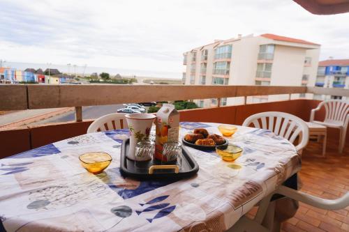 une table avec de la nourriture et des boissons sur un balcon dans l'établissement Port Pêche 4 Pers Terrasse vue mer Parking privé, au Barcarès
