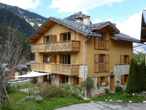 un grand bâtiment en bois avec un balcon dans l'établissement Charmant appart 3 pièces dernier étage, balcon sud, parking, près pistes à Pralognan - FR-1-464-106, à Pralognan-la-Vanoise