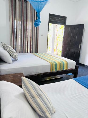 a room with two beds and a window at Werala Beach Resort in Kalpitiya