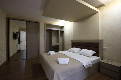 een slaapkamer met een groot bed met twee handdoeken erop bij Chanko Apartment in Borjomi