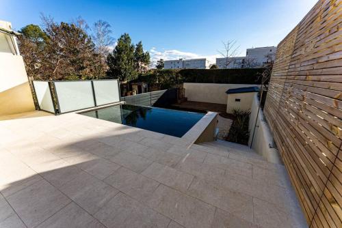 une cour avec une piscine à côté d'un bâtiment dans l'établissement Maison élégante avec piscine, à Tournon-sur-Rhône