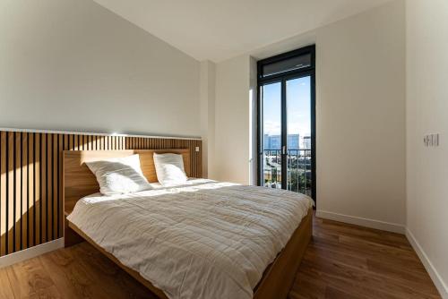 a bedroom with a large bed with a large window at Maison élégante avec piscine in Tournon-sur-Rhône
