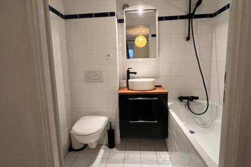 une salle de bain avec toilettes, lavabo et baignoire dans l'établissement Duplex 10 minutes from the beach in Trouville, à Trouville-sur-Mer