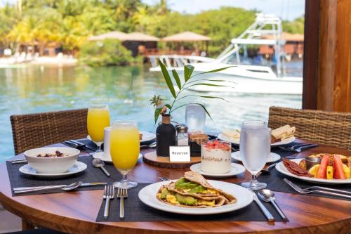 a table with plates of food and glasses of orange juice at Anthony's Key Resort in Sandy Bay