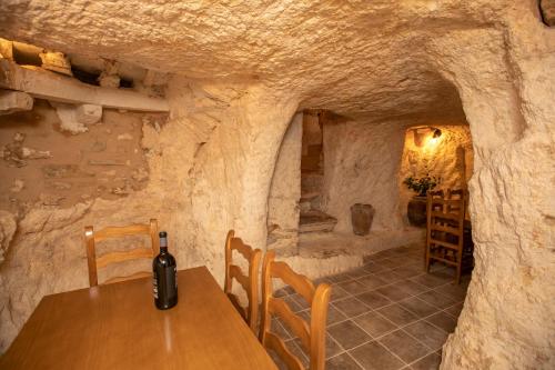 a wine bottle sitting on a table in a stone room at Casa Rural Gandia in Bocairent