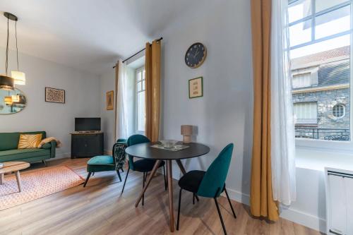 a living room with a table and chairs at Le Petit George V - Appartement design proche Thermes in Vichy