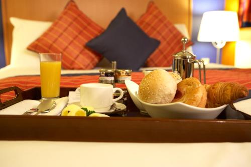 a tray with a tray of breakfast food on a bed at The Bull Hotel; Sure Hotel Collection by Best Western in Peterborough