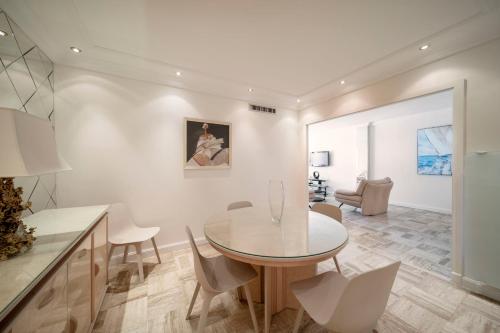 une cuisine et une salle à manger avec une table et des chaises dans l'établissement REF 30 - Cannes Croisette - Sea and gardens view apartment for rent, à Cannes