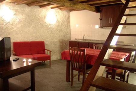 a living room with a red couch and a table at Casa da Fonte de Travanca in Travanca
