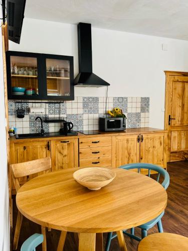 a wooden kitchen with a wooden table and chairs at Folwark Wierzchy in Wierzchy