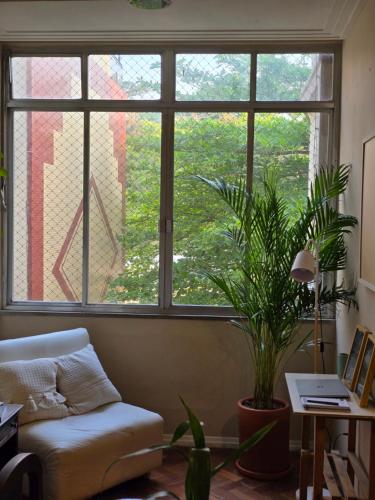 a living room with a couch and a large window at apartment cool & seafront Arpoador in Rio de Janeiro