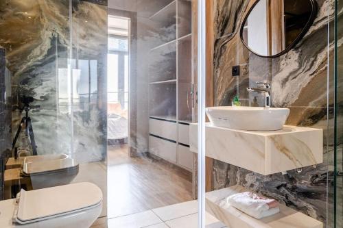 a bathroom with a toilet and a sink and a mirror at Modern Ocean View Apartment - Pestana Anfa Place in Casablanca