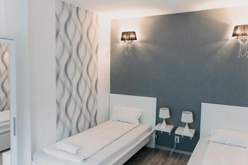 a small room with two beds and two lamps at Palma Vendégház in Szeged
