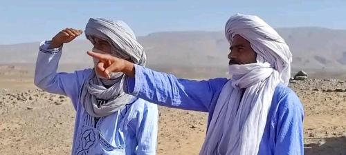 two women standing in the middle of the desert at AUBERGE SAHARA IRIKI & Désert Tours in Foum Zguid