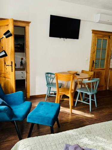 a living room with a table and chairs and a television at Folwark Wierzchy in Wierzchy