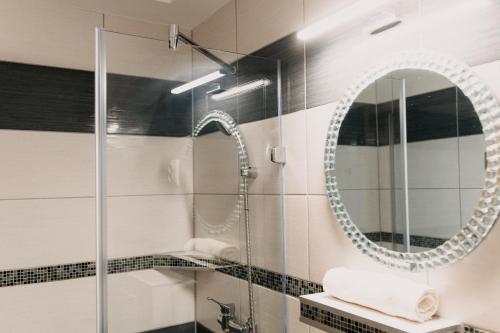 a bathroom with a shower and a mirror at Palma Vendégház in Szeged