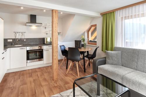 a kitchen and living room with a couch and a table at Pension Vorberghof- Bauernhofurlaub in Ramsau am Dachstein