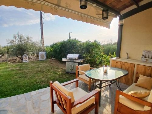 a patio with a table and chairs and a grill at Avdira Dreamin' in Xanthi