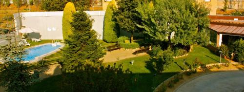 vistas panorámicas a un jardín con piscina y árboles en PARK SEDO Aparthotel, en Rubí