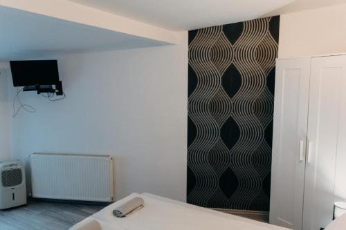 a bedroom with a black and white patterned wall at Palma Vendégház in Szeged