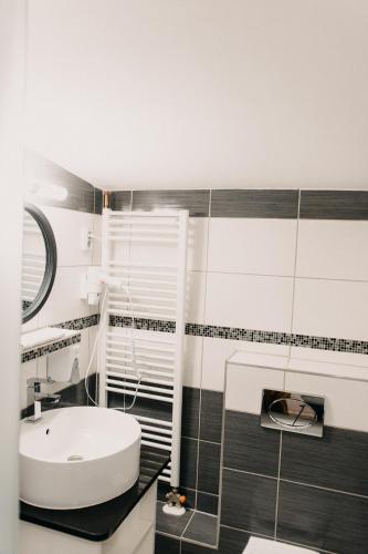 a bathroom with a white toilet and a sink at Palma Vendégház in Szeged
