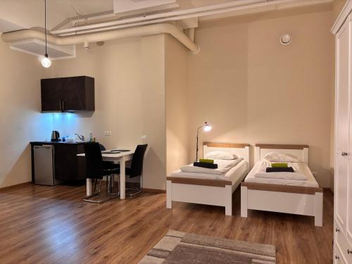 a room with two beds and a desk in it at Kastanimaja Apartments in Tartu